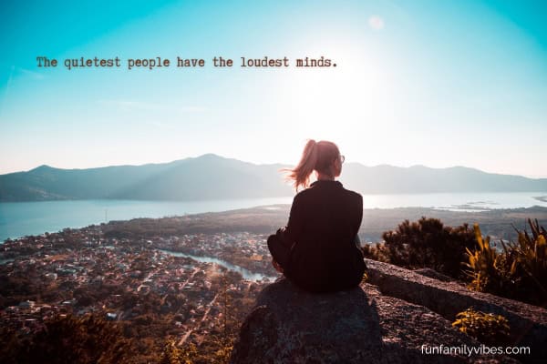 Woman sitting alone at the edge of a mountain, with quote overlay