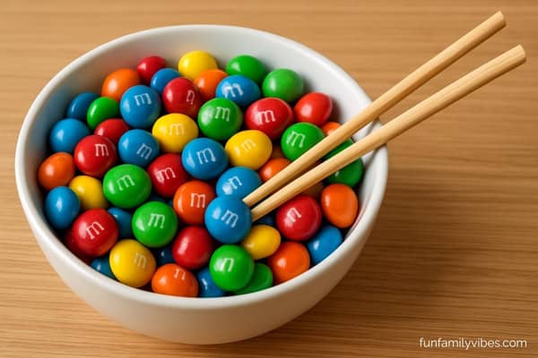 bowl of m&m candies with chopsticks
