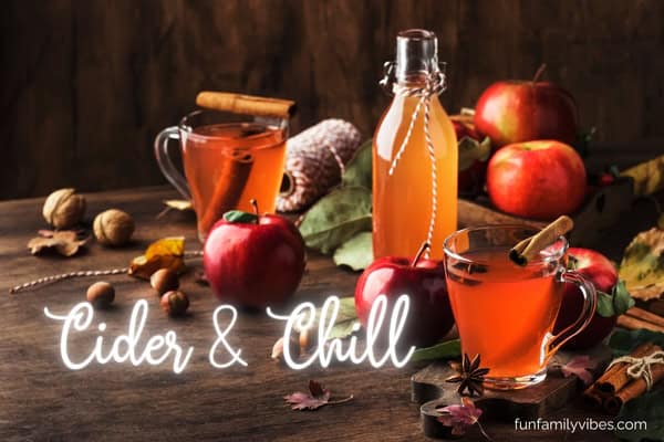 glasses of hot mulled apple cider with fall party name overlay