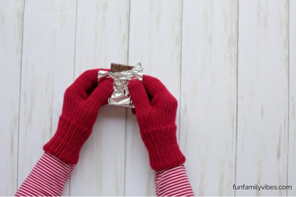 gloved hands unwrapping a candy bar
