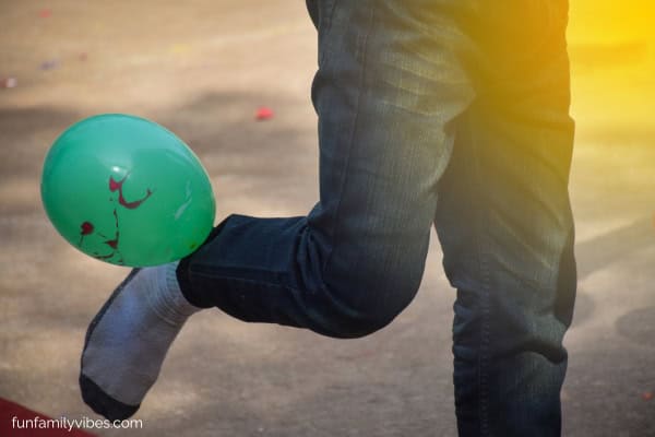 man's foot kicking a balloon