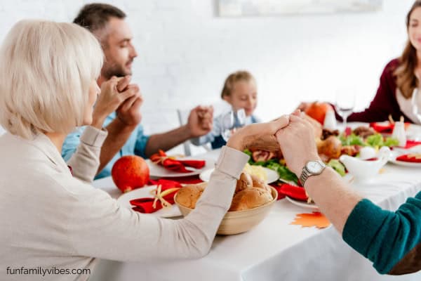 Family praying before Thanksgiving meal