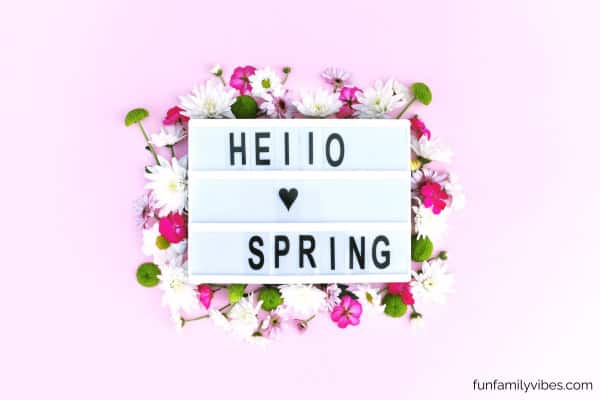 Lightbox on bed of flowers, with 'hello spring' inscription