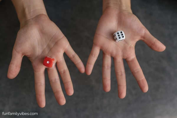 Hands holding 1 die in each hand