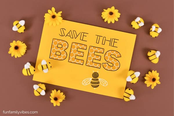 yellow paper with "save the bees" written on it, surrounded with felt bees and sunflowers