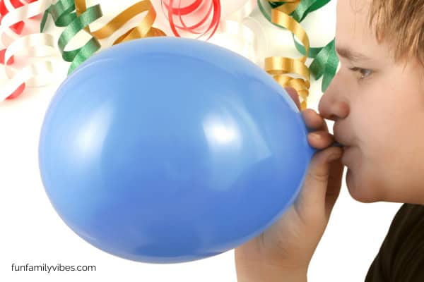 male blowing up a balloon