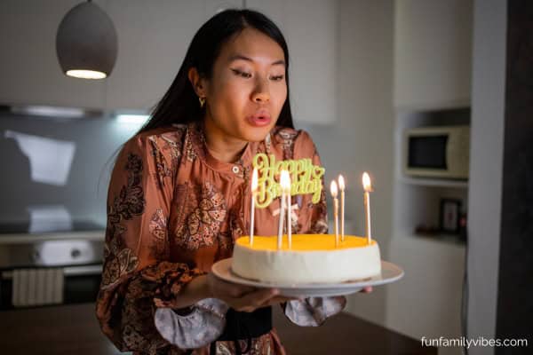 woman blowing out birthday cake candles