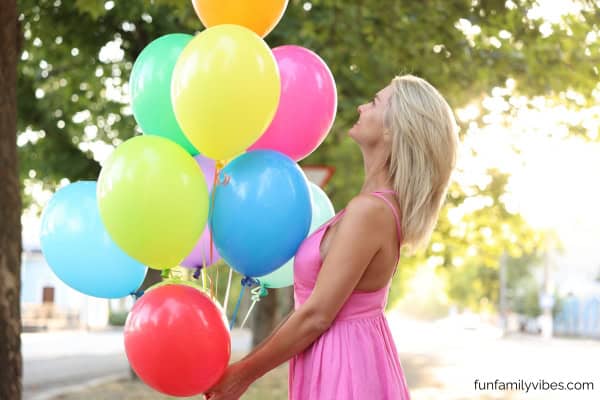 woman holding colorful balloons