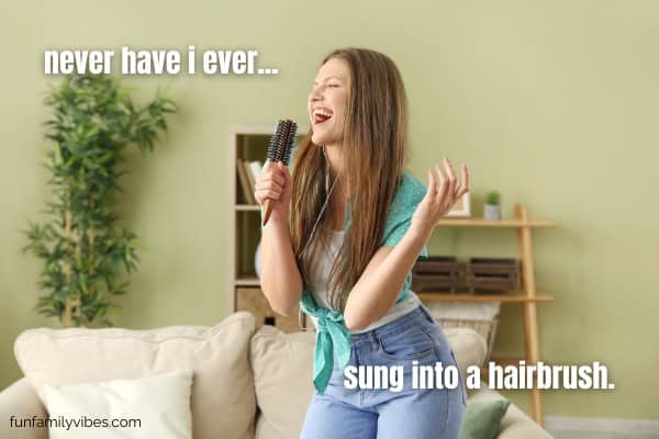 girl singing using hairbrush as microphone with never have i ever overlay