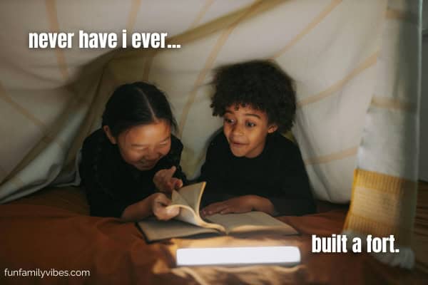 2 kids reading a book inside a fort