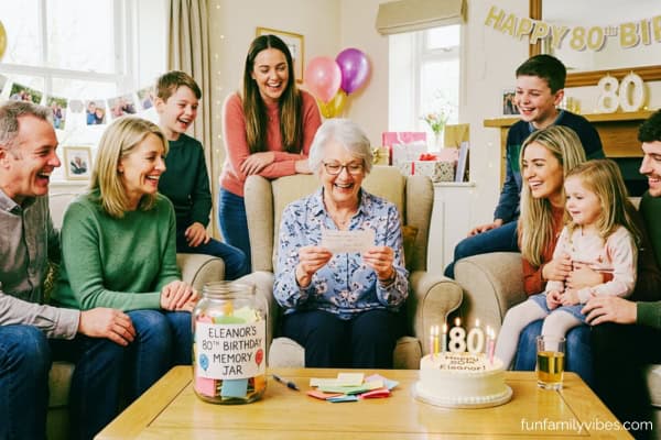 woman celebrating 80th birthday, playing memory jar game with her family