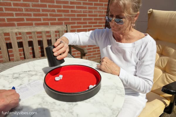 senior woman throwing dice to play Yahtzee