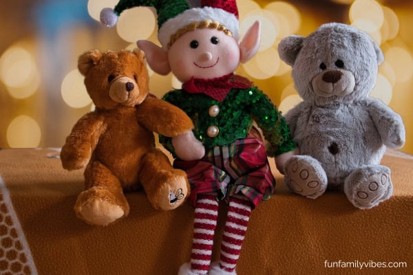 Christmas elf on a shelf beside teddy bears